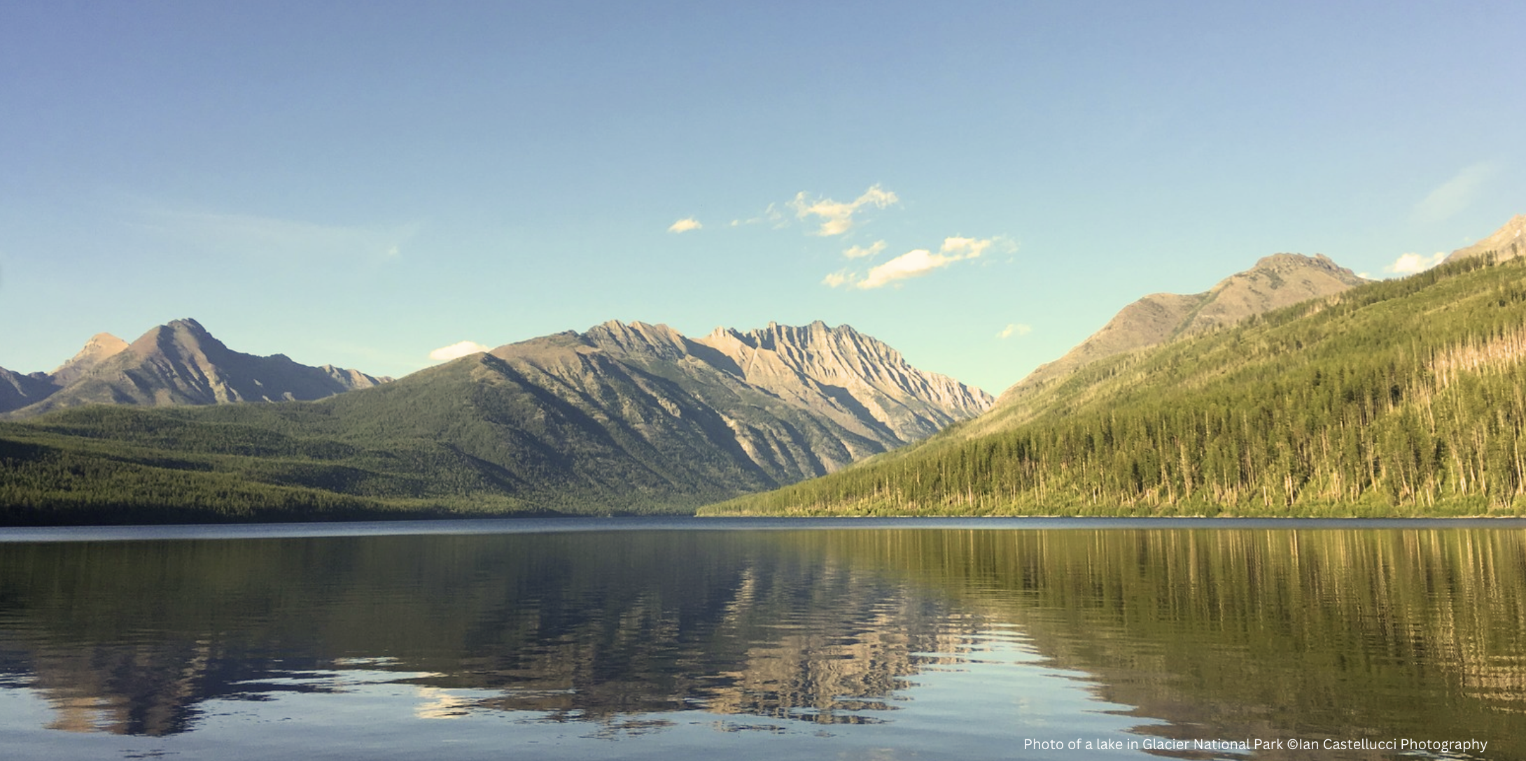 Rocky mountains tower over a lake in the late summer afternoon
